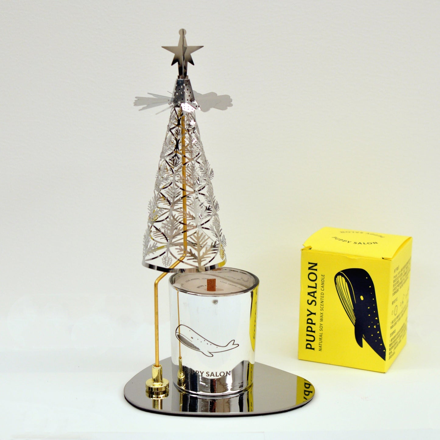Silver pine tree rotary candle holder with a matching silver candle and packaging box, ready to create a dynamic spinning display when lit.
