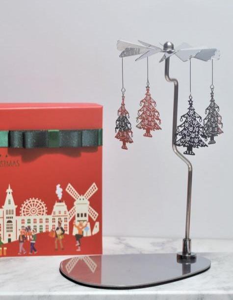 Silver metal rotary candle holder with a Christmas tree design. A festive decoration that spins when lit.