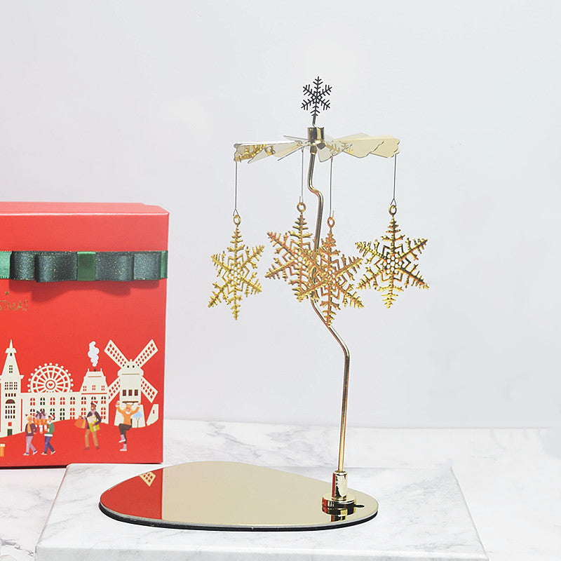 Gold metal rotary candle holder with a snowflake design. A festive decoration that spins when lit.