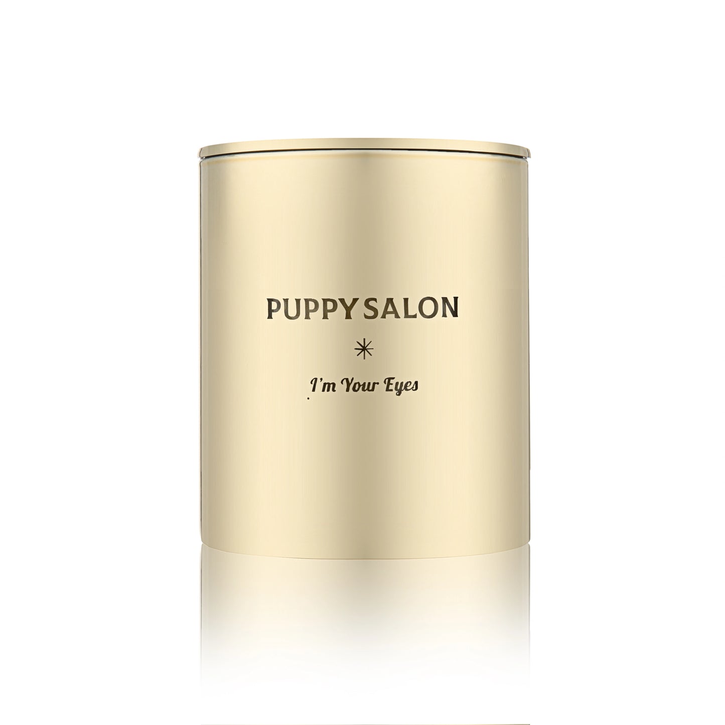 Isolated view of the Puppy Salon 'I am your eyes' candle. The gold cut-out glass jar creates a warm, glowing pattern when lit.