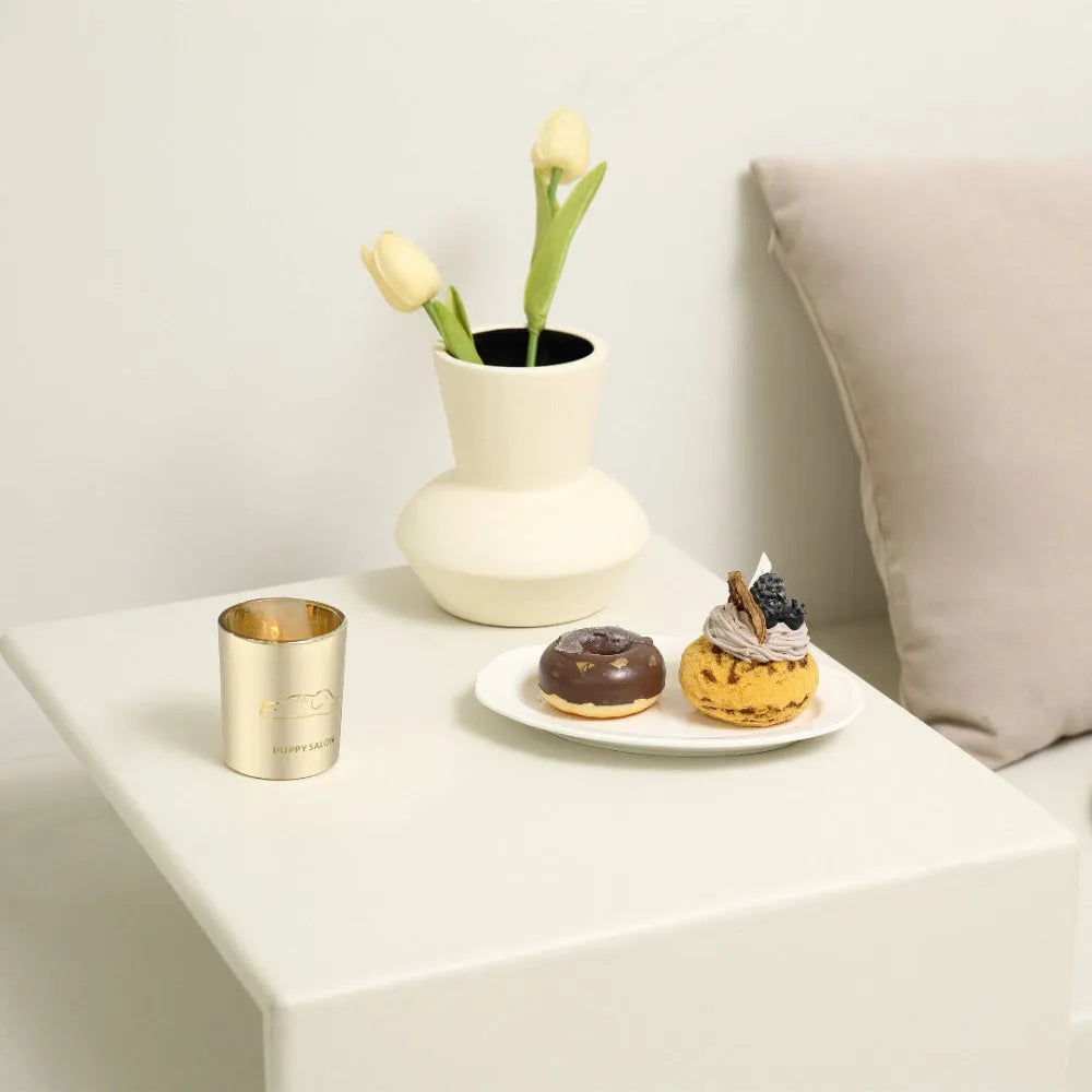 The Puppy Salon elephant candle glowing warmly on a living room side table, creating a cozy and elegant ambiance.