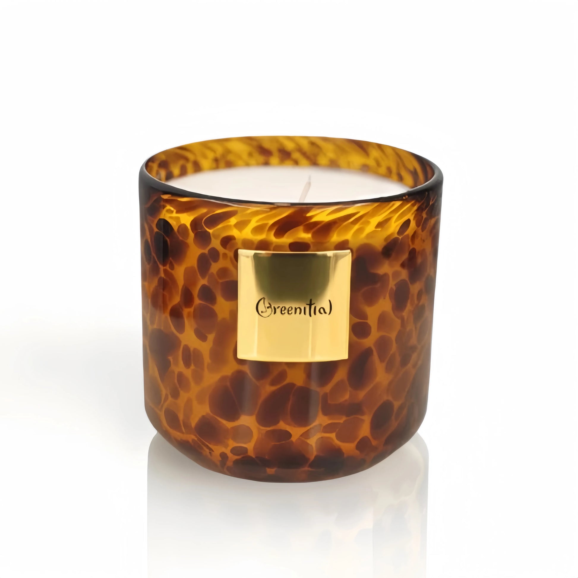 Greenitial scented candle in a handcrafted leopard-speckled glass jar.