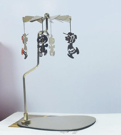 Gold metal rotary candle holder with a dog design. Uses heat from candles to spin and create dynamic shadows.