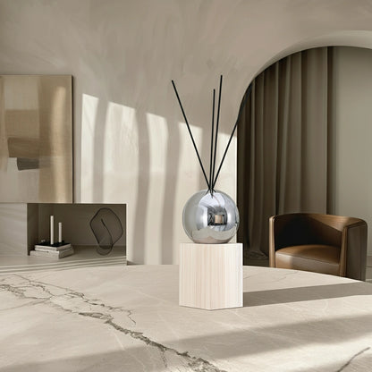 Natural wood stainless steel aroma diffuser bottle on a modern home office desk with plants and notebook, creating a calm workspace