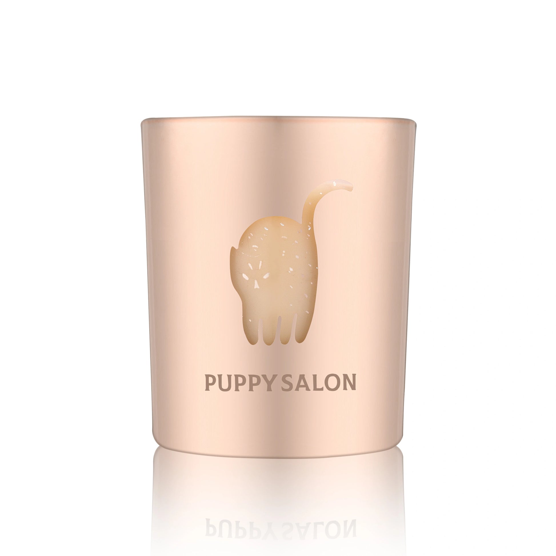 Isolated view of the Puppy Salon cat-inspired candle. The rose gold cut-out glass jar creates a warm, glowing pattern when lit.
