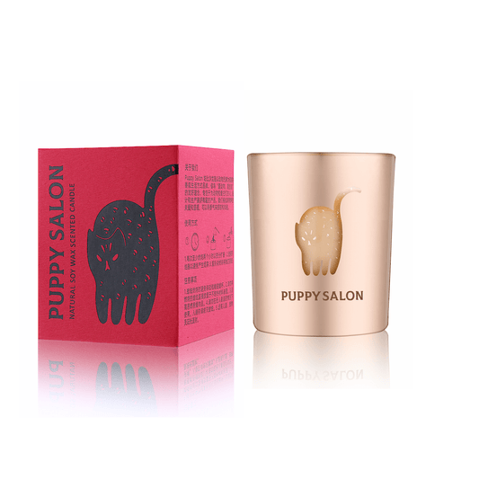 The cat-inspired candle by Puppy Salon with its gift box. Features a rose gold cut-out glass jar with cute cat designs.