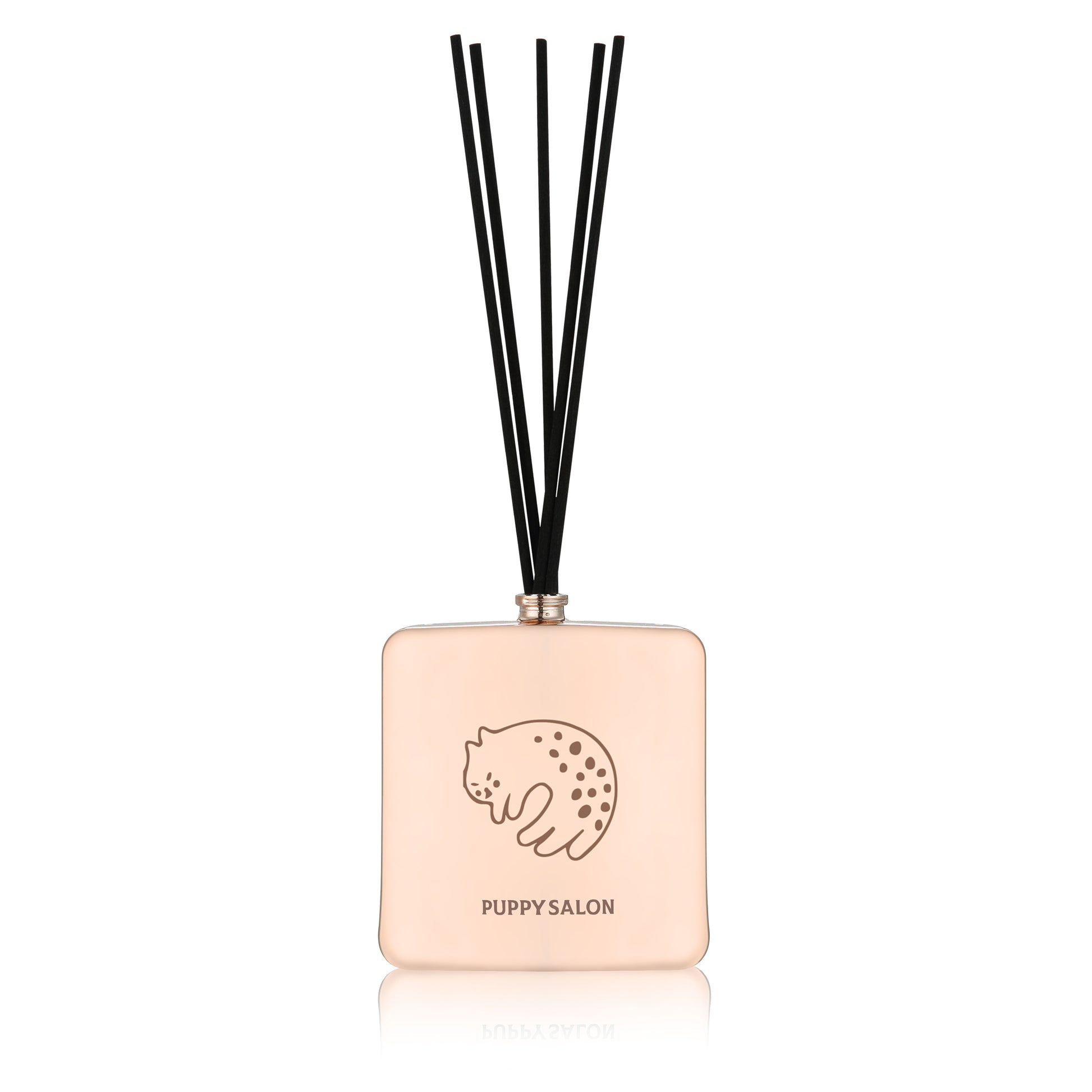 Isolated view of the Puppy Salon cat-inspired reed diffuser. The rose gold glass bottle with intricate cut-out designs adds a modern touch to any space.