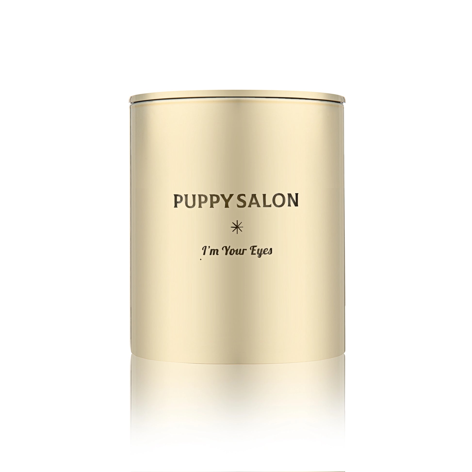 Isolated view of the Puppy Salon 'I am your eyes' candle. The gold cut-out glass jar creates a warm, glowing pattern when lit.