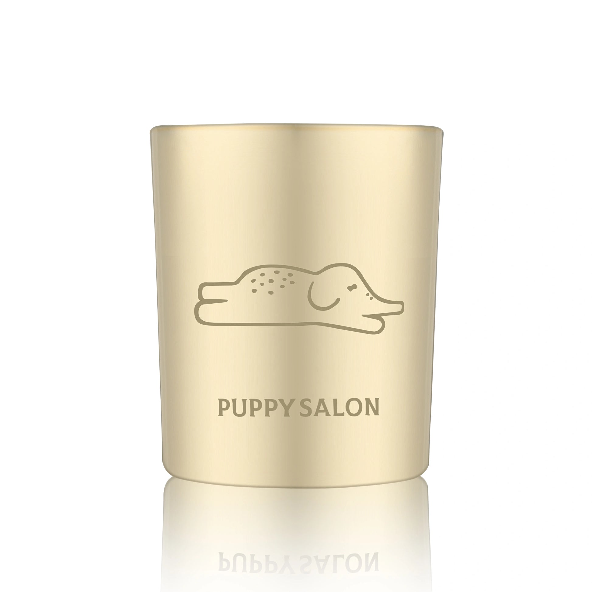 Isolated view of the Puppy Salon 'An Elephant Never Forgets' candle. The gold cut-out glass jar creates a warm, glowing pattern when lit.