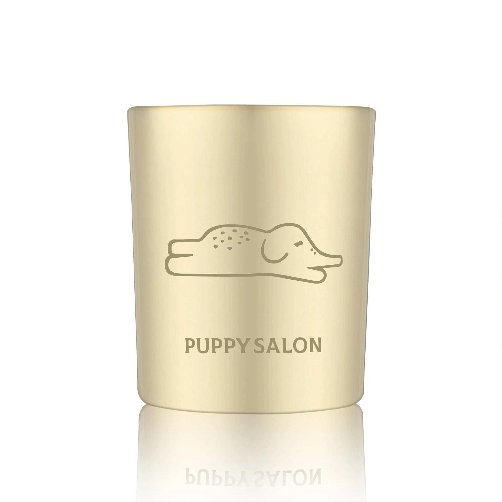 Isolated view of the Puppy Salon 'An Elephant Never Forgets' candle. The gold cut-out glass jar creates a warm, glowing pattern when lit.