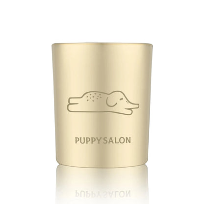 Isolated view of the Puppy Salon 'An Elephant Never Forgets' candle. The gold cut-out glass jar creates a warm, glowing pattern when lit.