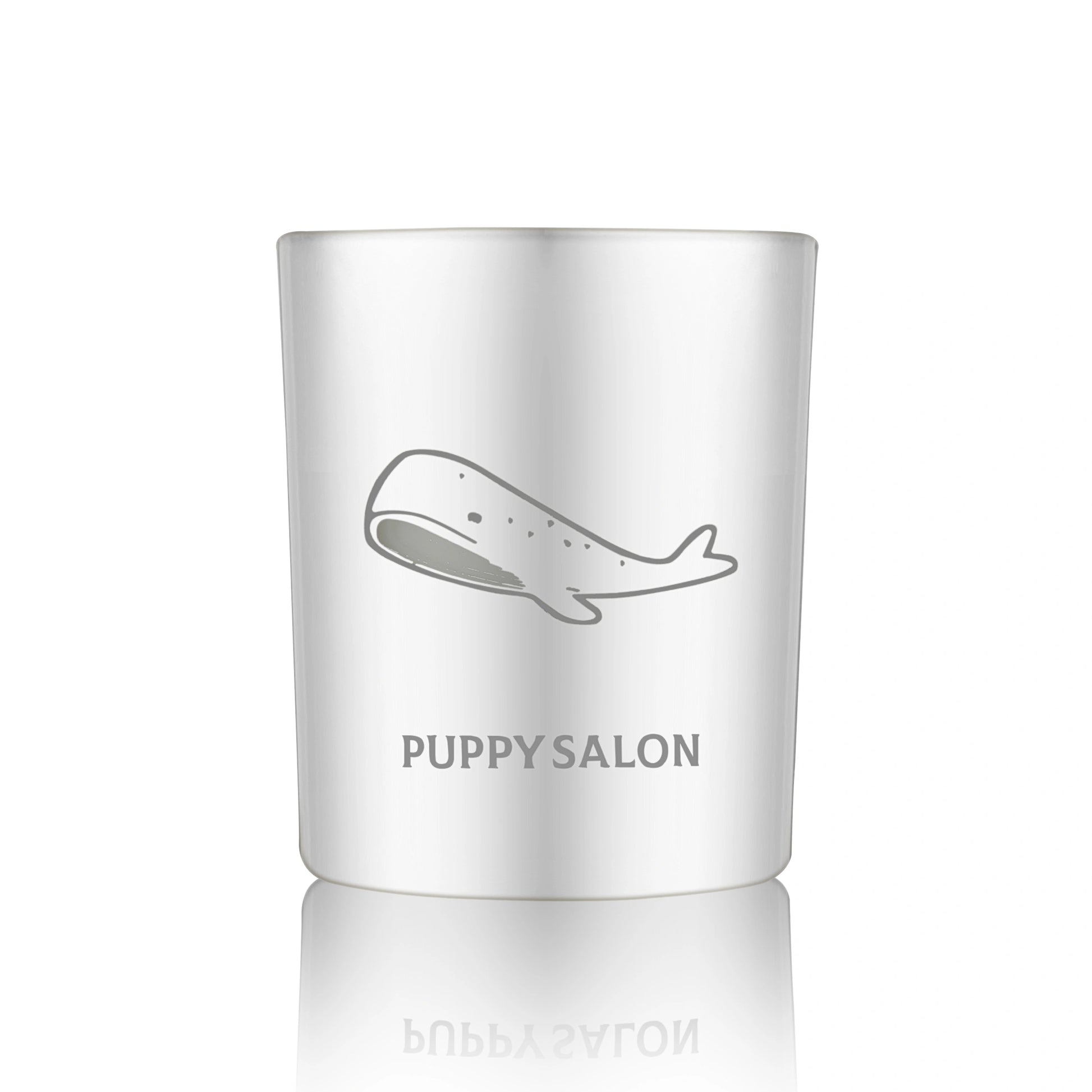 Isolated view of the Puppy Salon whale-inspired candle. The silver cut-out glass jar creates a wonderful, glowing pattern when lit.